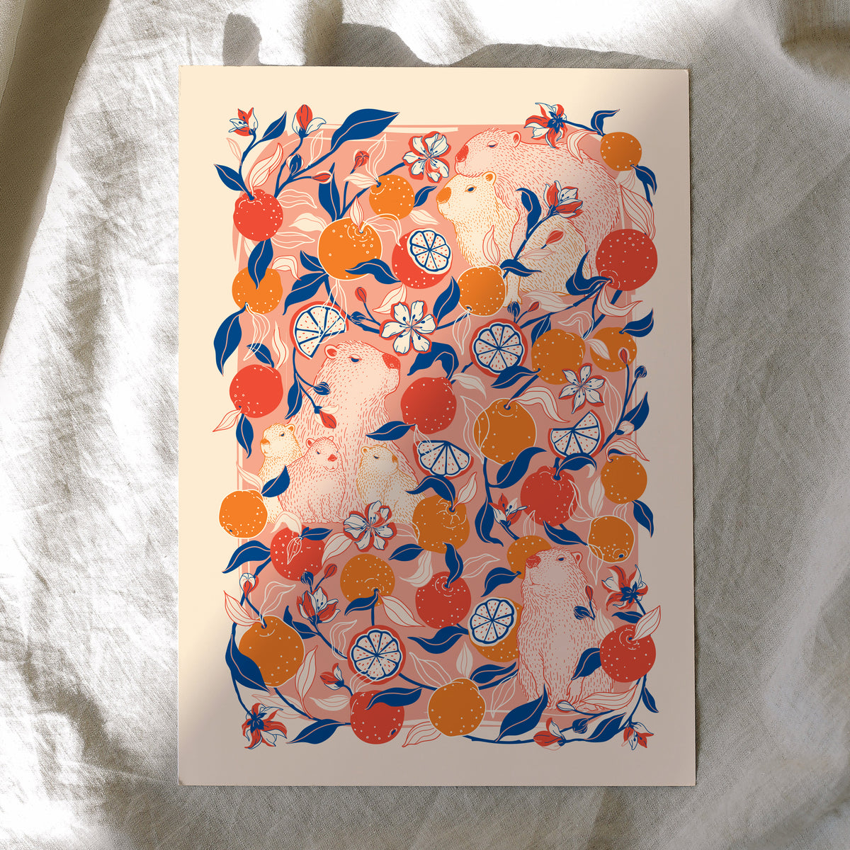 Decorative card with capybaras and yuzu orange pattern on a textured fabric background