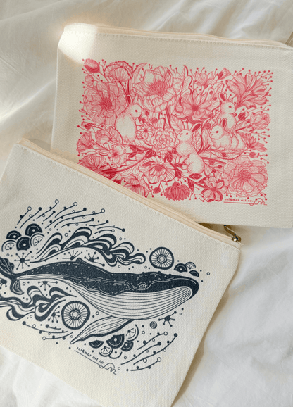 Cotton canvas zipper pouches with floral bunny and whale illustrations on a soft background.