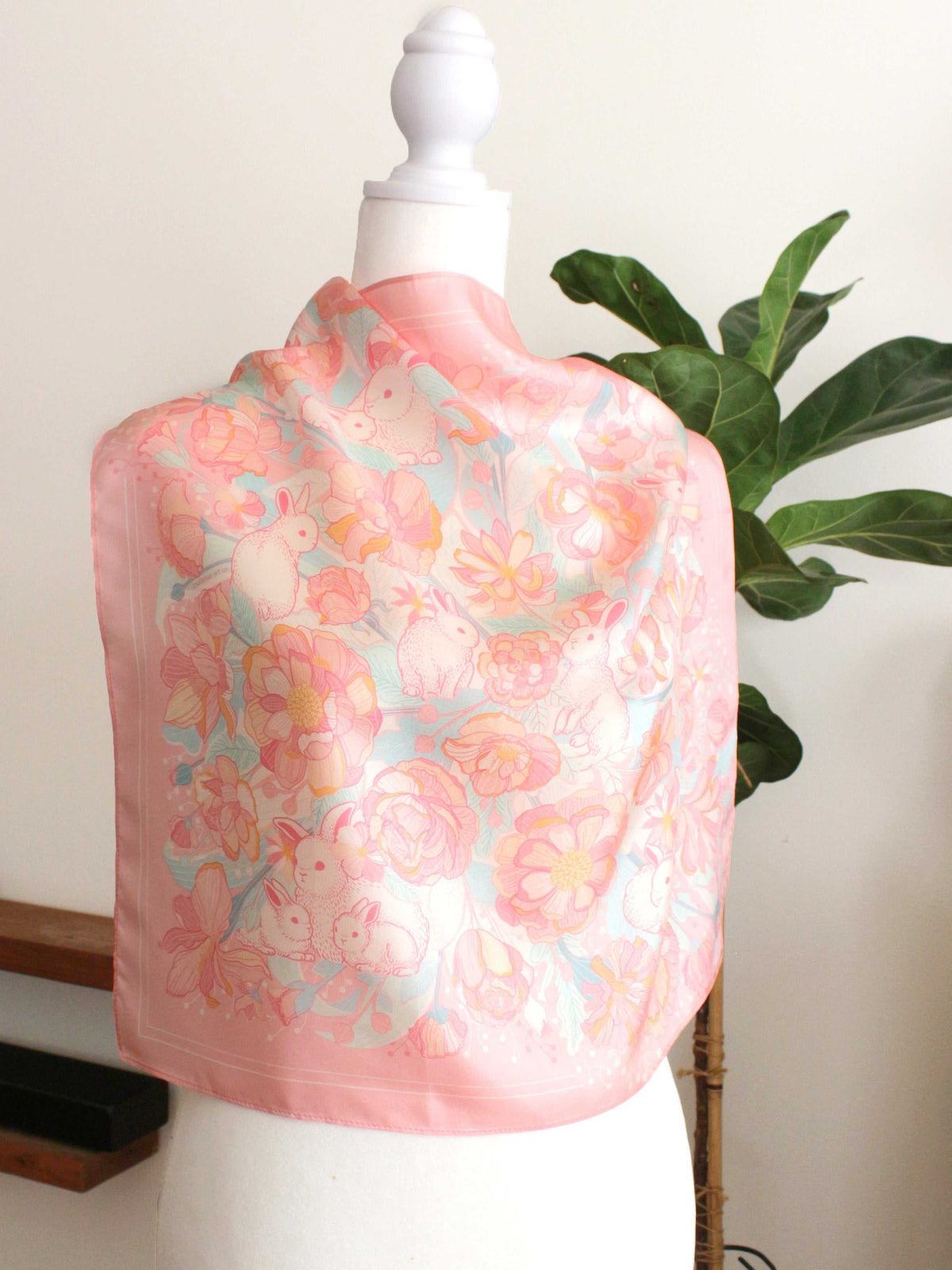 Bunny in the Floral Breeze Silk Twill Scarf draped on a mannequin, showcasing floral and rabbit art design.