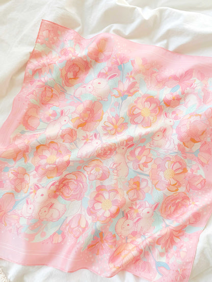 Bunny in the Floral Breeze Silk Twill Scarf featuring pastel bunnies and flowers on a soft pink background.