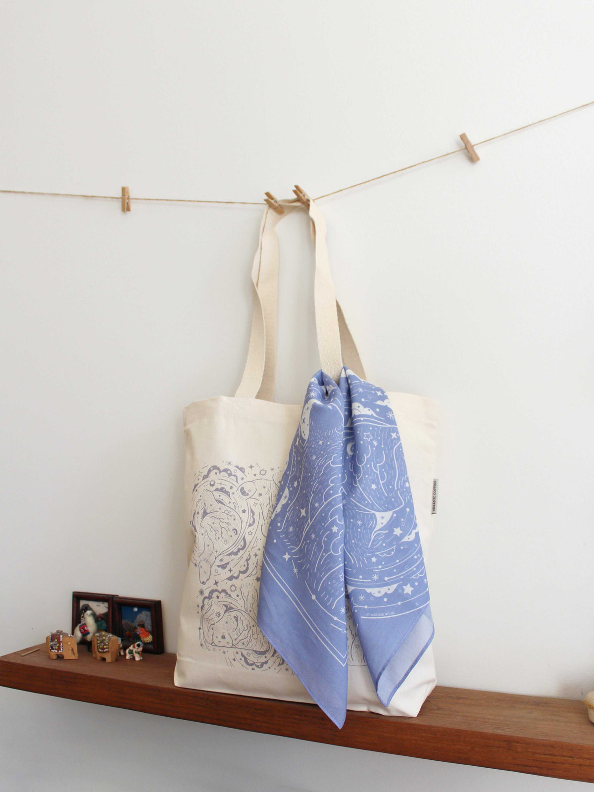 Lavender bandana scarf draped on a natural tote bag, showcasing a starry Northern Sky design.