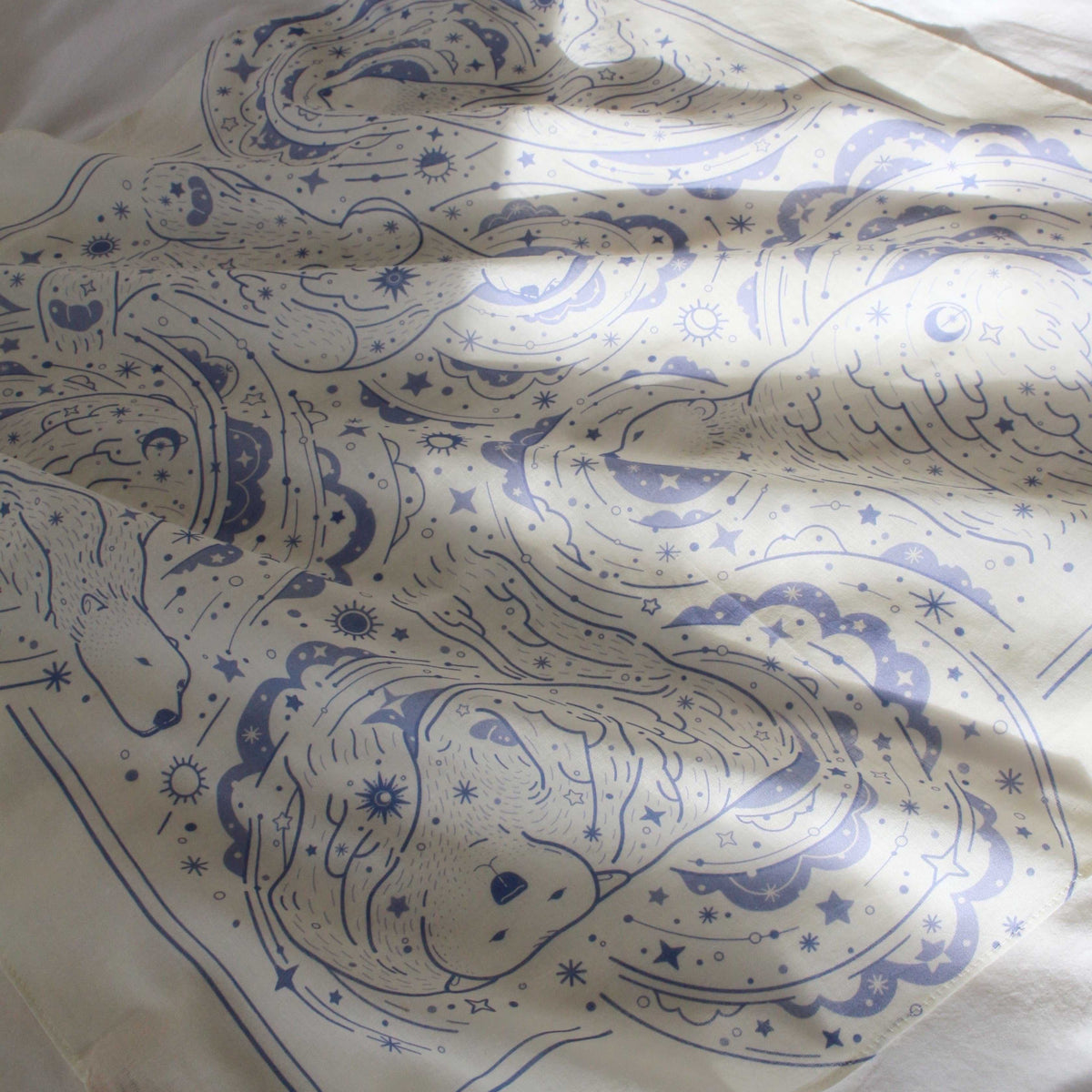 Off-white bandana scarf featuring polar bear and northern sky art in soft cotton fabric.