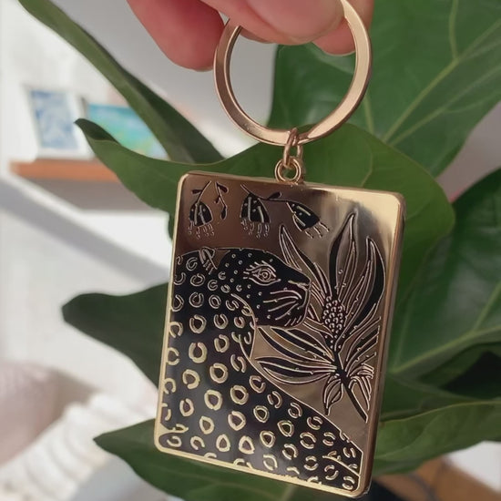 Leopard and flowers enamel keychain with gold-plated metal, detailed illustration and carabiner hanging option.