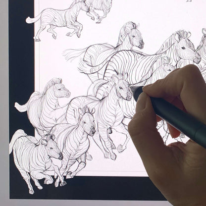 Illustration of a herd of zebras being drawn on a digital tablet by an artist's hand.