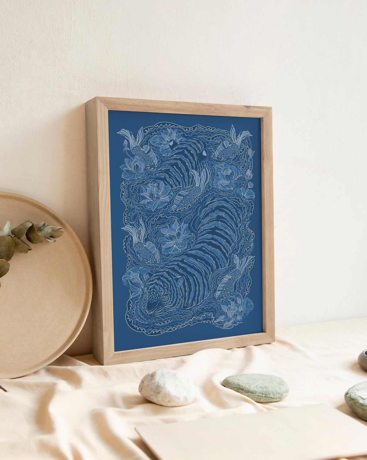 Framed blue tiger artwork on a white wall with decorative elements below