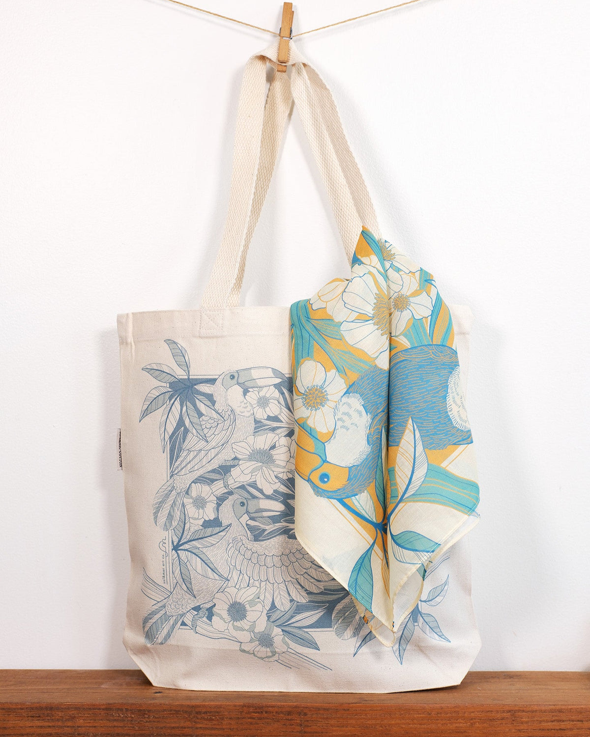 Tote bag with Toucan & floral design and matching scarf on a wooden surface