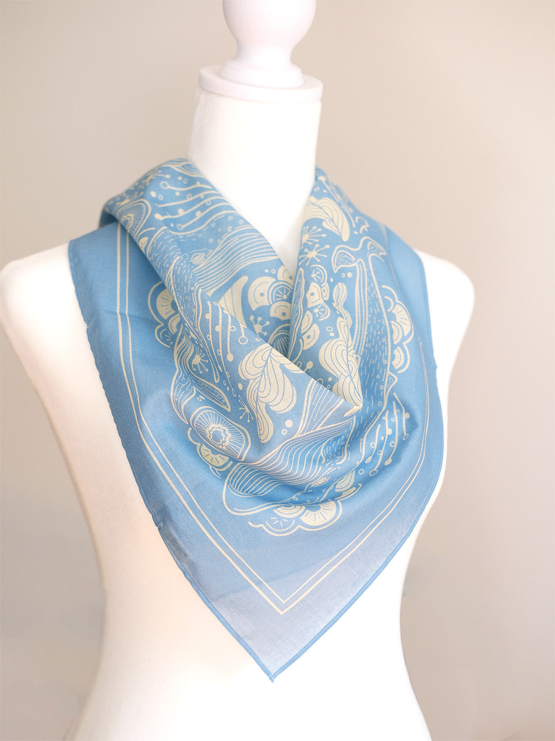 Light blue whale and ocean bandana scarf displayed on a mannequin, perfect for accessories or décor.