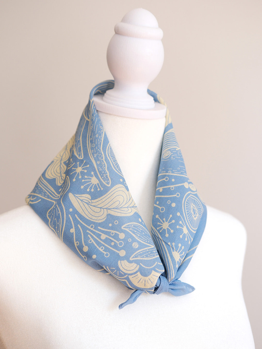 Light blue whale and ocean bandana scarf displayed on a mannequin, showcasing its unique design and soft cotton fabric.