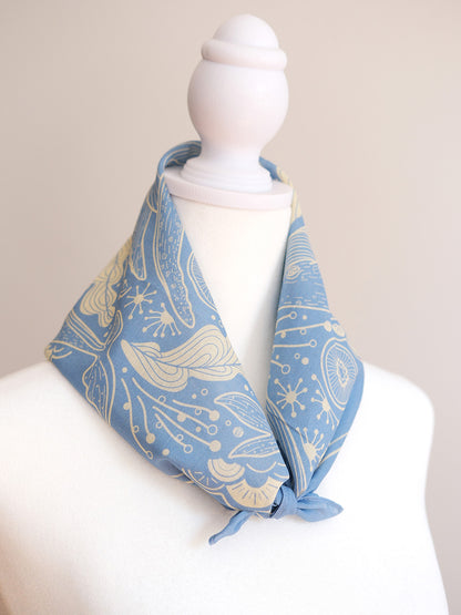 Light blue whale and ocean bandana scarf displayed on a mannequin, showcasing its unique design and soft cotton fabric.