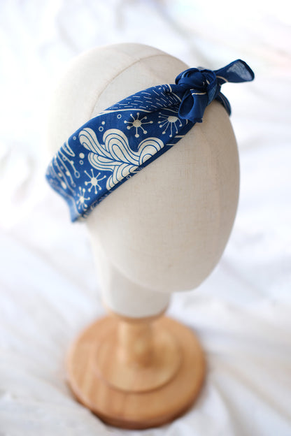 Navy whale and ocean bandana scarf displayed on a mannequin head, perfect for hair accessories and decor.
