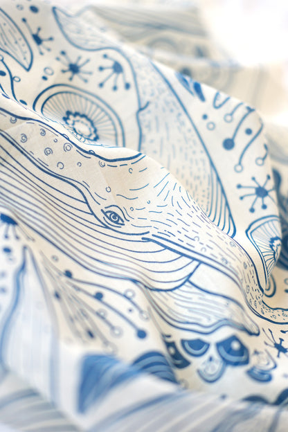 Off-white bandana scarf featuring detailed blue Humpback whale and ocean art design, perfect for accessories or decor.