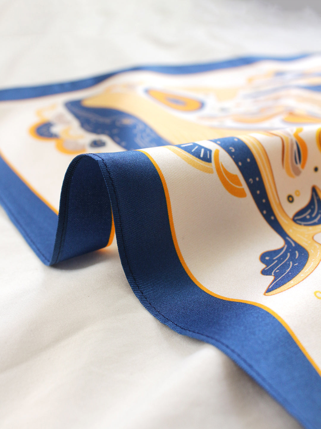 Whale and Ocean Silk Twill Scarf showcasing detailed art, perfect for accessories and decor, folded on a soft surface.