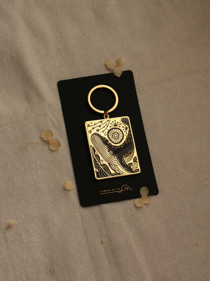 Humpback whale and ocean enamel keychain on display card with gold plating.