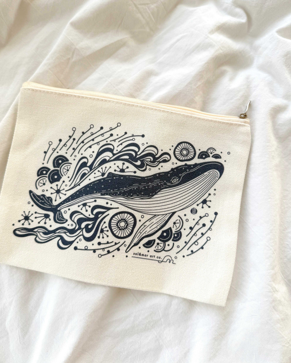 Canvas zipper pouch featuring an illustrated whale design with ocean motifs, perfect for cosmetics or stationery.