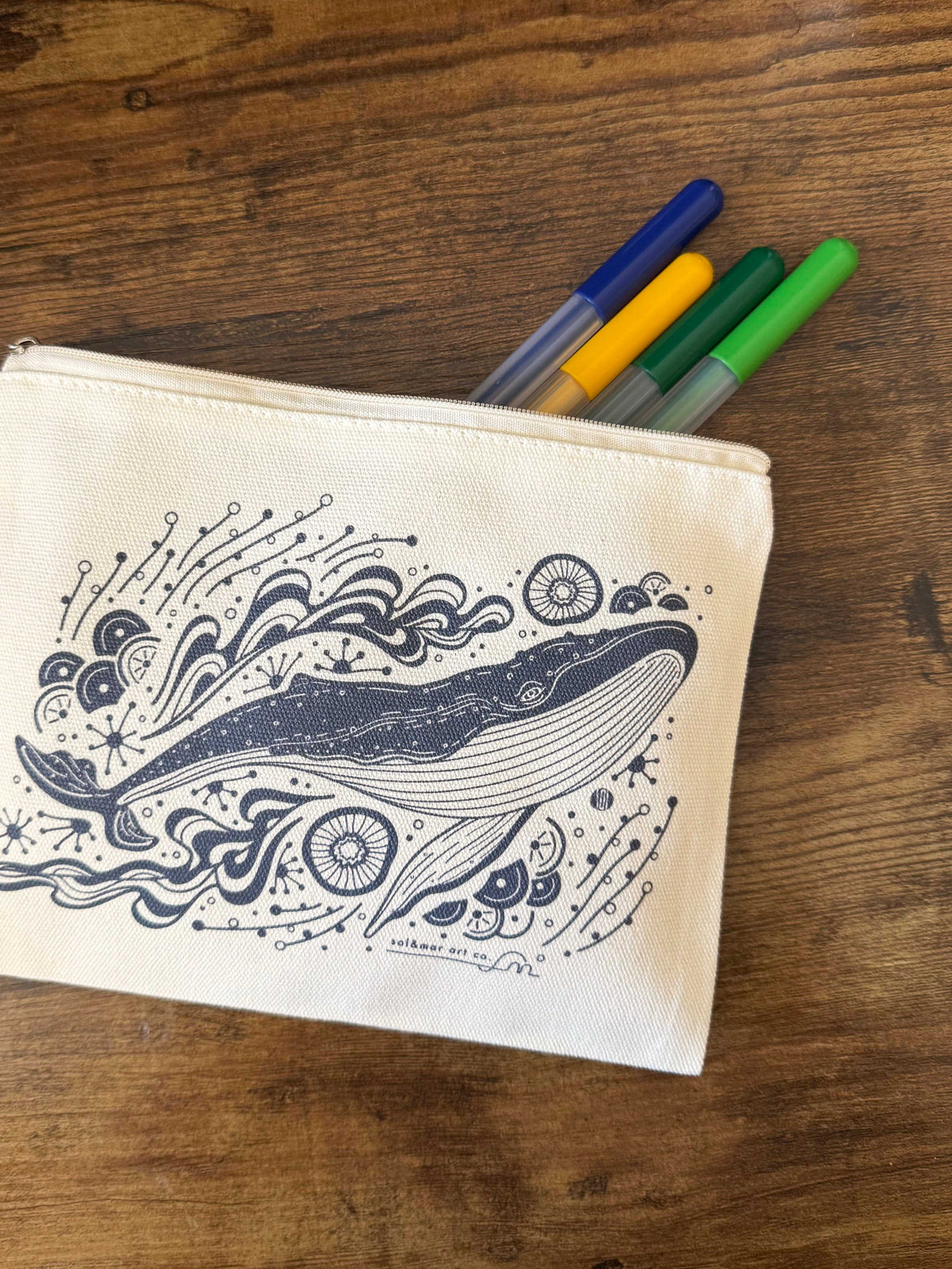 Canvas zipper pouch featuring whale illustration and colored markers, perfect for cosmetics or stationery.