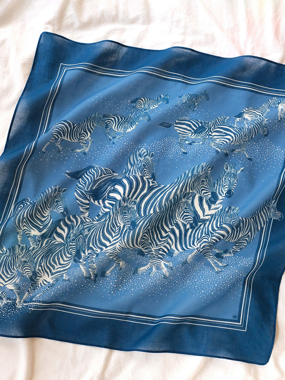Blue bandana scarf featuring a herd of zebras running, perfect for hair, accessories, or decor.