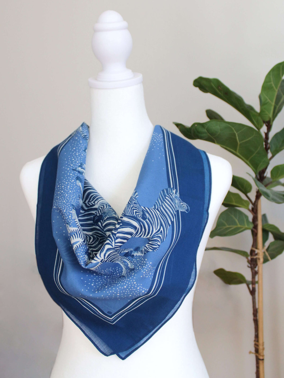 Blue zebra bandana scarf featuring a herd of zebras, 22x22 inches, soft cotton for versatile styling and year-round wear.