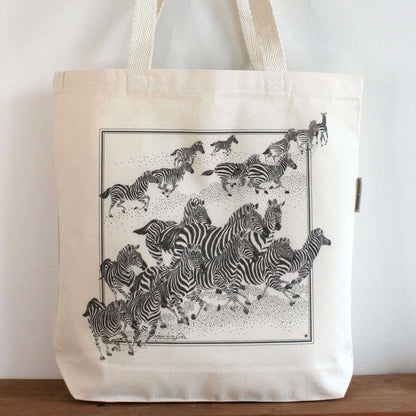 Zebra 'New Beginning' canvas tote bag featuring a stunning herd of zebras in motion, ideal for everyday use.