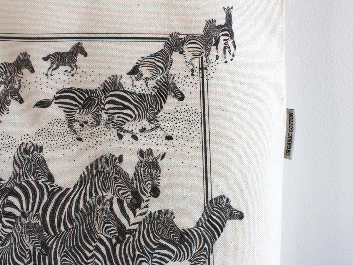 Herd of zebras illustrated on an organic cotton canvas tote bag, perfect for everyday use and stylish outings.