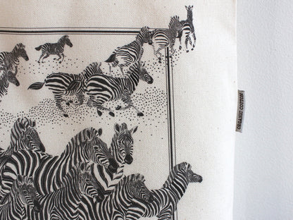 Herd of zebras illustrated on an organic cotton canvas tote bag, perfect for everyday use and stylish outings.
